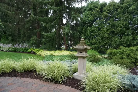 A stone lantern among ornamental grasses and evergreens