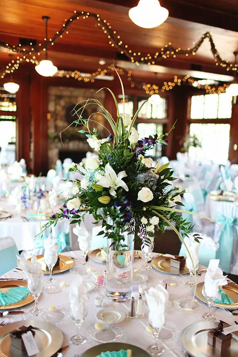A tall white floral centerpiece at a wedding